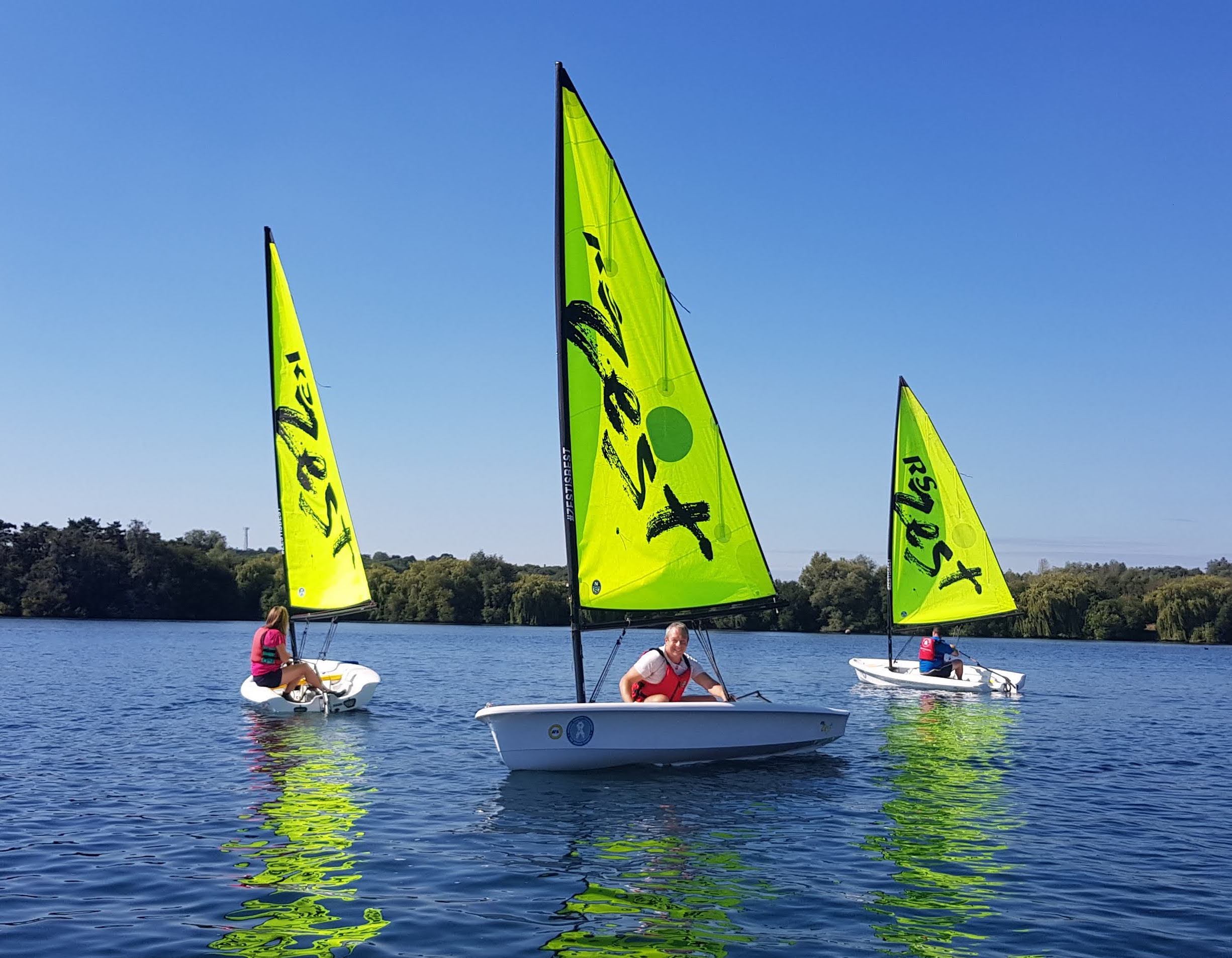 Adult's sailing on a bright sunny day